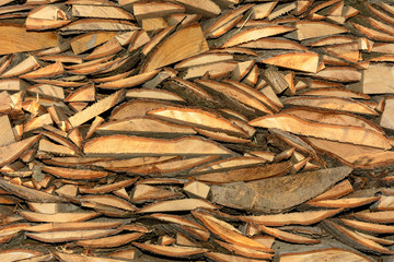 The texture of a wooden cut board with bark, which is chaoticly slippery