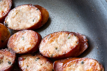 Macro close up on sliced sausage in a pan