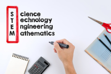 STEM - Science, Technology, Engineering, Mathematics education concept. Hand holding a black marker on white background