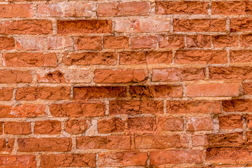 a weathered broken red brick wall