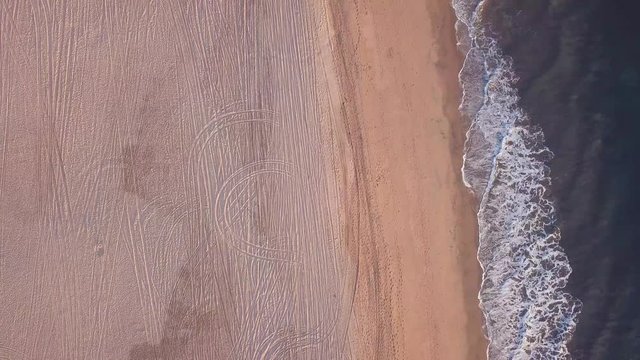 Aerial drone above the beach sands ocean ascending