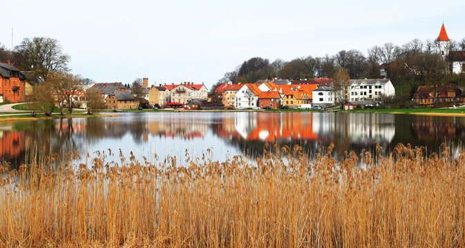 Colorful old town houses and church with lake reflection in spring morning in Talsi Latvia.