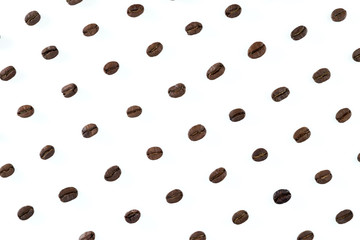 Fototapeta na wymiar A pattern of roasted coffee beans placed in diagonal rows on a white background.