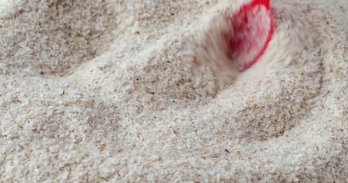 Close video of using a red spoon to stir psyllium husks then take a spoonful at the end.