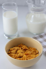 cornflakes with milk in a plate on a white table