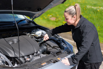 Fototapeta na wymiar A woman mechanic repairing a car engine at roadside