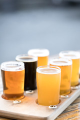 Flight of six craft beer in pint glasses on a wood tray