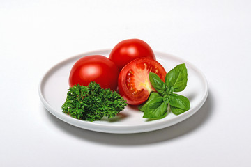 Fresh tomatoes with basil and parsley on plate