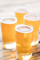 Close up on a collection of pale ales and pilsners in pint glasses