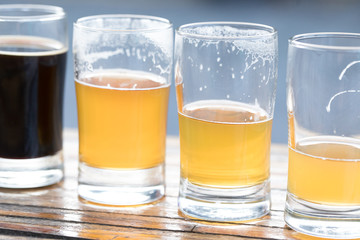 Row of pint glasses with decreasing volumes of of beer