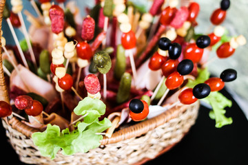 meat bouquet of cucumber,olive and sausage appetizer in a basket