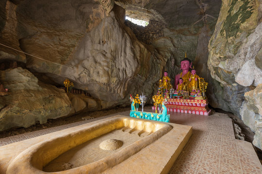 Buddha's footprint and several Buddha statues on altar inside the Tham Sang (or Xang) Cave, also known as the Elephant Cave, near Vang Vieng, Vientiane Province, Laos.