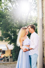 Fototapeta premium Sensual couple holding hands outdoors in summer time, newlywed couple on honeymoon in France, romantic getaway concept, stylish husband hugging hipster wife