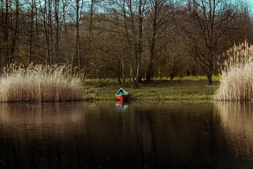 Fototapeta na wymiar Red boat lying on the bank of a lake