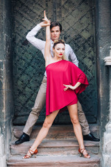 Sexy couple of dancers posing near old wall outdoors, newlywed couple on honeymoon dancing outdoors, elegant motions and poses by man and woman