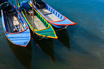 Colourful traditional Asian fishing boat in the blue sea.
