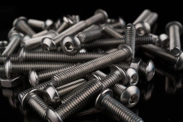 metal fasteners screws and nuts on black background. screw isolated on the black backgrounds. Nuts with bolts closeup