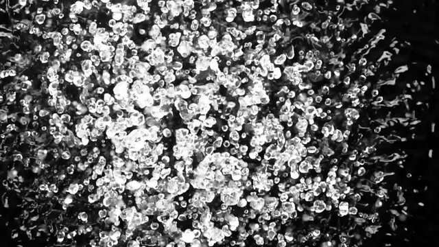 Beautiful patterns movement of water drops obtained by boiling water effect. Black background. Slow motion