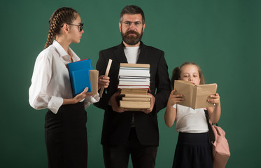 School time of sisters and father in library. Literature lesson and reading grammar book. Education...