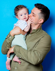 Young father and son on blue background