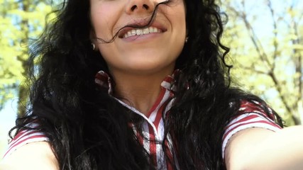 Happy woman swings with camera in hands on swing