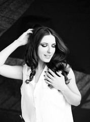 beautiful smiling woman in white shirt stand  studio shoot  on dark background.