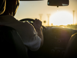close up silhouette of man driving a car on a sunset during golden hour