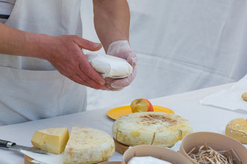 Obraz na płótnie Canvas The seller on a marketplace sells handmade cheese, close-up