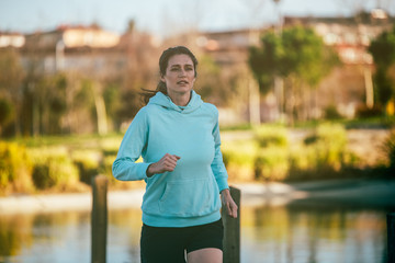 Young fit blonde woman running in the park