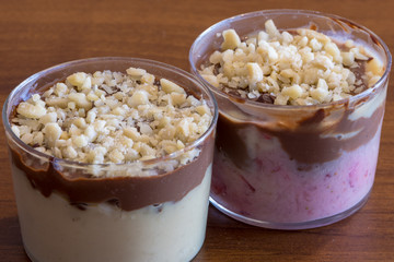 Spoon cake with two creams and almonds, two desserts in transparent glasses