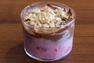 Sweet spoon with strawberry and chocolate cream, dessert in transparent glass