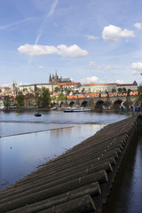 Obraz premium Spring green Prague Lesser Town with gothic Castle and Charles Bridge above River Vltava in the sunny Day, Czech Republic