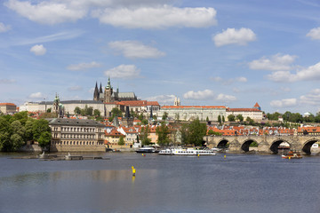 Obraz premium Spring green Prague Lesser Town with gothic Castle and Charles Bridge above River Vltava in the sunny Day, Czech Republic