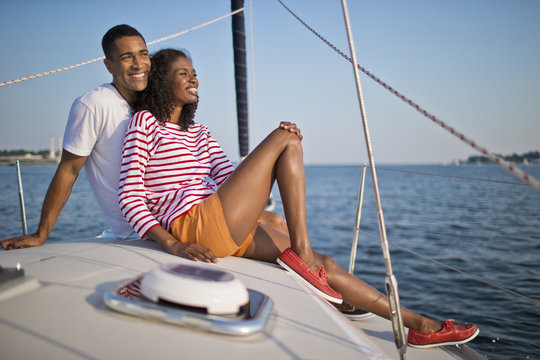Happy young couple relaxing and having fun while sailing.