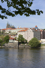 Fototapeta na wymiar Spring green Prague Lesser Town with gothic Castle above River Vltava in the sunny Day, Czech Republic