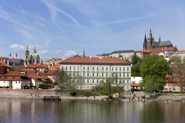 Fototapeta premium Spring green Prague Lesser Town with gothic Castle above River Vltava in the sunny Day, Czech Republic