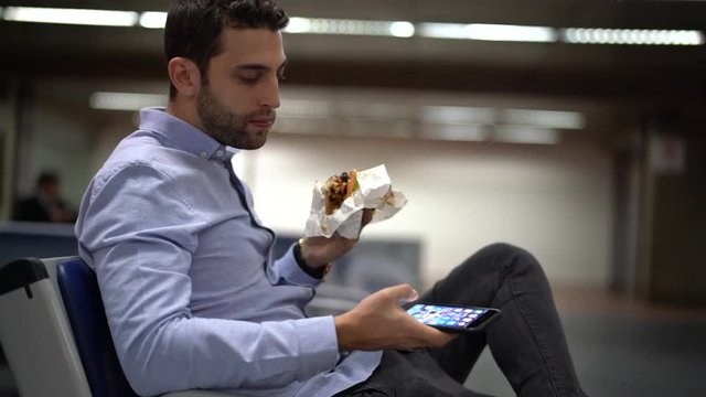 Guy eating sandwich at airport