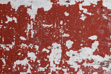 Distressed painted wall texture with red paint stains and white background. Painted texture in obsolete paint.