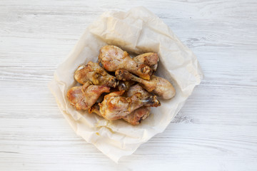 Roasted chicken legs on a white wooden surface, top view