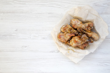 Fried chicken legs on a white wooden background, top view. From above. Copy space.