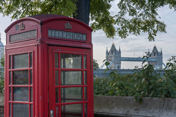 The red telephone box, on background Tower Bridge, two famous icons of London, England.