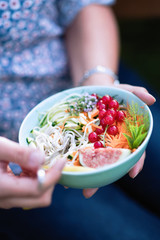 Close-up on hands holding a bowl of mixed salad
