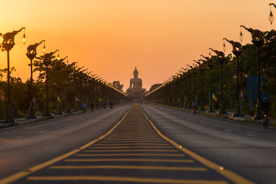 Beautiful sunset biggest Buddha Wat Pikul Thong temple is famous place for worship of the sacred travel destination at Singburi province Thailand.
