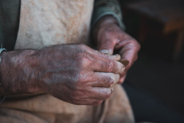 Fototapeta premium Potter works with clay, craftsman hands close up, kneads and moistens clay