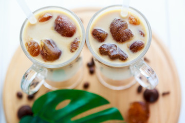 Two cups of ice coffee with coffee beans on wooden table, selective focus. summer delicious drink