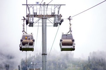 Photo of funicular in mountains against background of misty sky