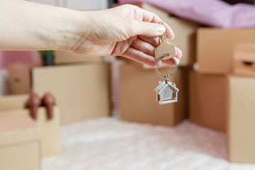 Photo of cardboard boxes, man's hand with keychain, open door in new apartment.