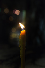 Yellow candle lit in the night