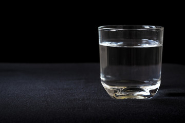 Glass of water on the dark background