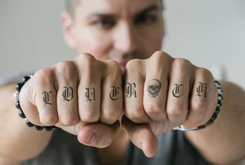 Foto op Plexiglas Closeup of knucle tattoos of a man © Rawpixel.com